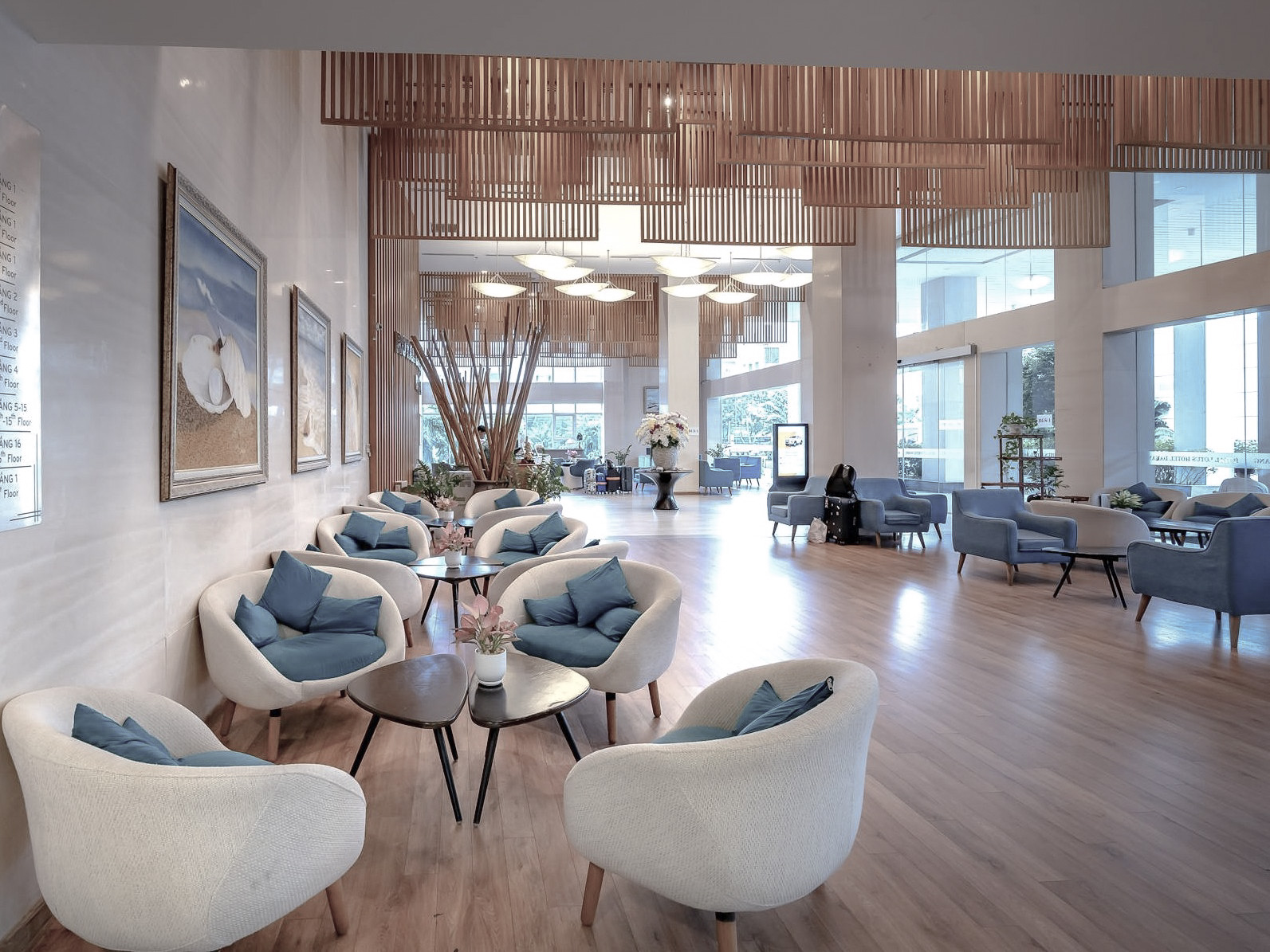 Bright and modern boutique hotel lobby with elegant seating, natural wood finishes, and floor-to-ceiling windows